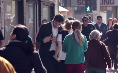 Hombre viendo su celular choca violentamente a la gente